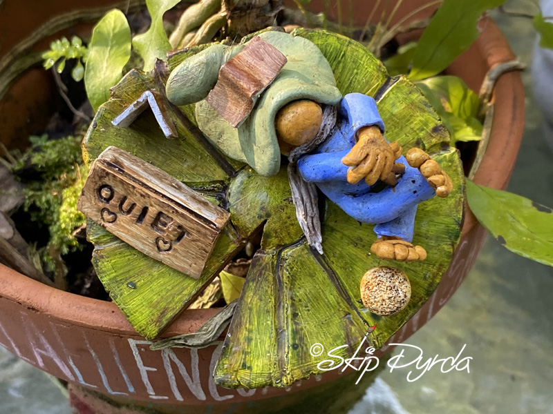 Painted clay gnome figurine sleeping on a lily pad