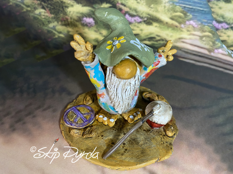 Painted clay gnome figurine flashing the peace sign