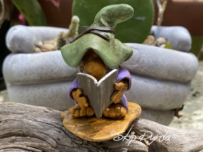Painted clay gnome figurine as a bookworm