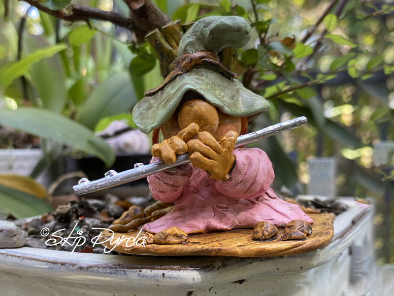 Painted clay gnome figurine as a flute musician